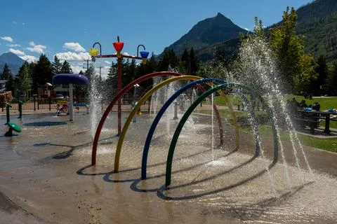 Vibrant splash pad with rainbow arches, perfect for a sunny day of fun. Stock Photos