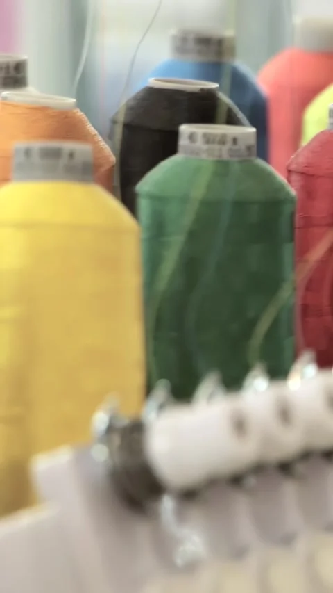 Vibrant Spools Ignite Automated Fabric Artistry in a Busy Factory Stock-Footage 344617945