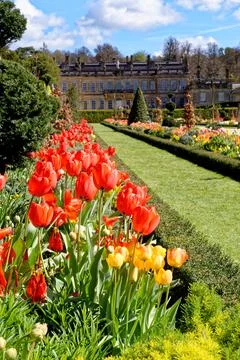 Vibrant spring flower borders and manicured grass paths leading to the hist.. Stock Photos