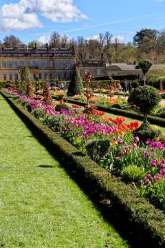 Vibrant spring flower borders and manicured grass paths leading to the hist.. Stock Photos