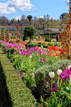 Vibrant spring flower borders and manicured grass paths leading to the hist.. Stock Photos