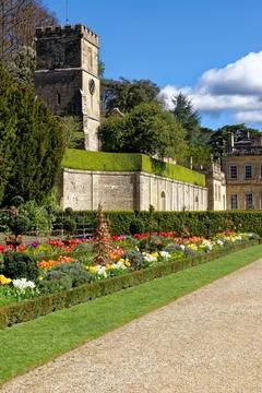 Vibrant spring flower borders and manicured grass paths leading to the hist.. Stock Photos