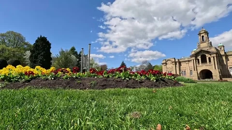 Vibrant spring flowers and Cartwright Hall in Lister Park Stock Footage 333793951