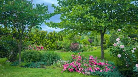 Vibrant Spring Garden Scene Surrounded by Lush Greenery and Colorful Flowers Stockfoto's