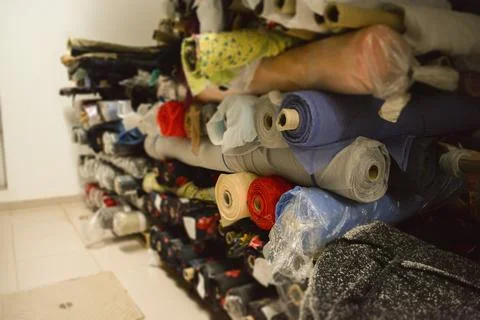 A vibrant stack of multi-colored fabric rolls, arranged in diverse palette... Foto stock