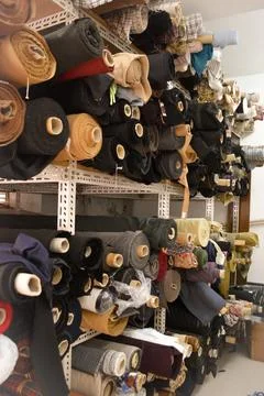 A vibrant stack of multi-colored fabric rolls, arranged in diverse palette... Foto stock