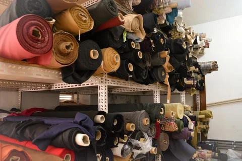 A vibrant stack of multi-colored fabric rolls, arranged in diverse palette... Foto stock