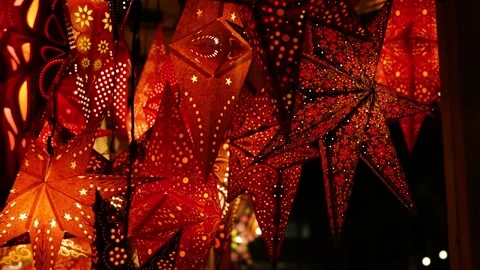 Vibrant star shaped lanterns in red, orange, gold patterns glowing hanging .. Video stock 322772858