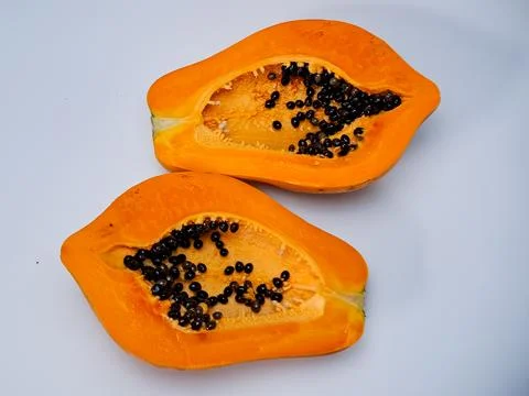 Vibrant still life featuring two halves of a papaya, showcasing the contras.. Stock Photos