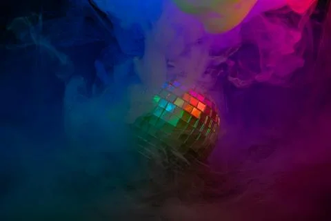 A vibrant stock image showcasing a disco ball surrounded by colorful smoke,.. Stock Photos