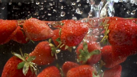 Vibrant strawberries falling and floating in aquarium full with water Stock Footage 111945815