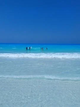 A vibrant summer scene featuring a pristine beach with white sand and stunning Stock Photos