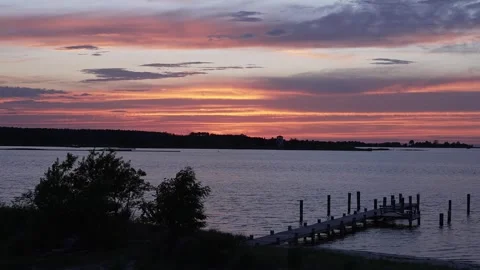 Vibrant Summer Sunset Over Lake with Wooden Dock and Dramatic Colorful Sky Stock Footage 340053615