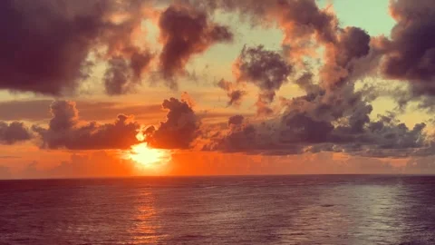 The vibrant sun sets over the calm ocean waters creating a dramatic sky wit.. Stock Footage 338282762