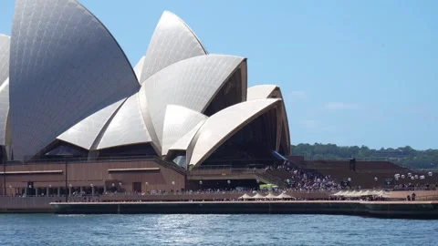 A vibrant, sunny daytime view of the iconic Sydney Opera House from the water Stock Footage 341498297