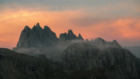 Vibrant Sunrise over the cloud covered peaks of the Dolomites, Italy. 8k Stock Footage 214473752
