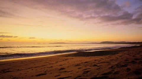 Vibrant Sunset Beach Stroll: Wide Angle of Golden Sky, Waves, and Silhouette Stock Footage 319877064