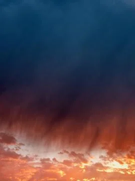 Vibrant sunset clouds, deep blue merging into fiery orange Stock Photos
