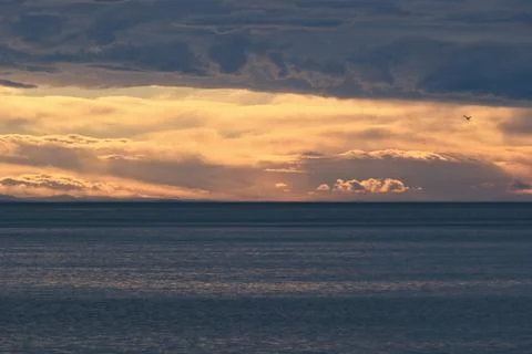 Vibrant Sunset Clouds Over the Calm Sea Stock Photos