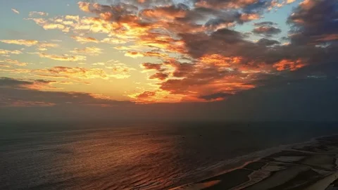 Vibrant Sunset Clouds Reflecting on Ocean and Sandy Coast Qisha Island China Stock Footage 339513683