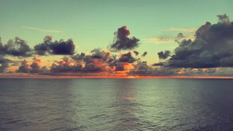 Vibrant sunset with dramatic clouds reflecting on serene ocean surface in t.. Stock Footage 338281943