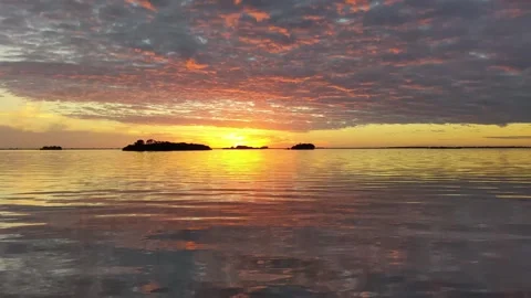 Vibrant sunset over calm Gulf waters with colorful clouds Cedar Key Florida Stock Footage 333473917