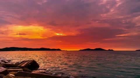 Vibrant Sunset over Calm Ocean Waters with Silhouetted Foreground Vidéo 310216965
