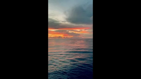 Vibrant sunset over calm ocean waters with colorful clouds reflected in the.. Stock Footage 338280293