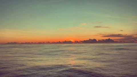Vibrant sunset over calm ocean waves with a warm sky Stock Footage 338281776