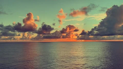 Vibrant sunset over calm ocean with colorful clouds reflecting in water Stock Footage 338281942
