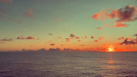 Vibrant sunset over the calm ocean with scattered clouds creating a serene .. Stock Footage 338282057