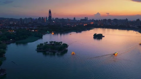 Vibrant Sunset over Daming Lake, Jinan with City Skyline and Illuminated Boats Stock Footage 331118829
