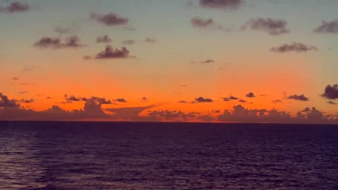 Vibrant sunset over the ocean with scattered clouds in the sky creating a s.. Stock Footage 338282062