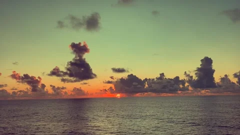 Vibrant sunset over the ocean with scattered clouds in the sky Stock Footage 338282195