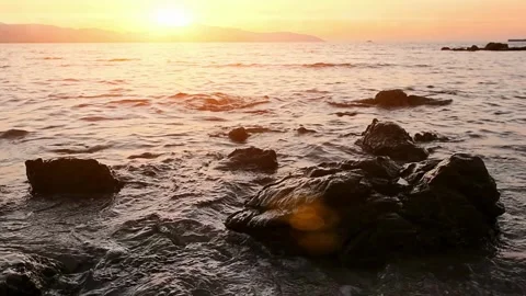 Vibrant Sunset Over Ocean Waves Crashing on Rocky Shore Stock-Footage 310245097