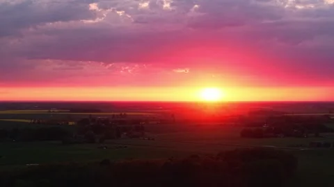 Vibrant sunset over a rapeseed field, rich colors paint the evening sky from Stock Footage 311435101