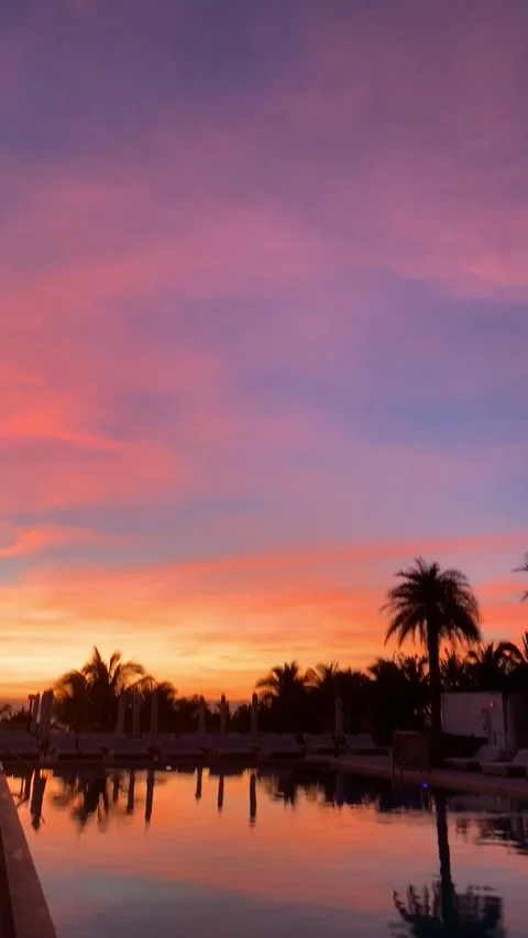 Vibrant sunset over reflective resort pool  Stock Footage 136340366