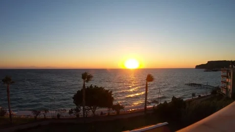 Vibrant sunset over tranquil ocean waves, showcasing the suns descent Stock Footage 319528721