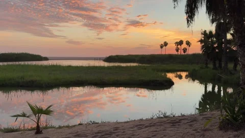 Vibrant Sunset Reflection in Calm Coastal Lagoon Stock Footage 285186081