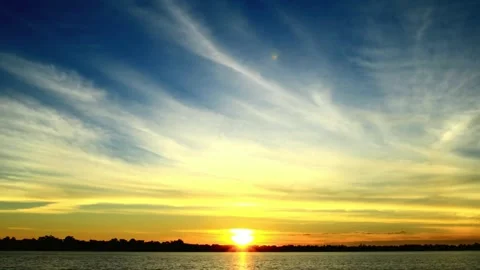 Vibrant Sunset Sky with Dramatic Cloud Formations over Calm Water Stock-Footage 310816828