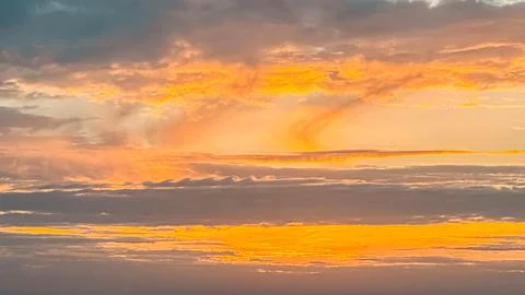 Vibrant sunset sky with dramatic clouds showcasing a blend of orange, yellow, Stock Photos