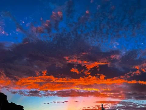 Vibrant sunset sky with dramatic orange and blue clouds New Zealand Фото