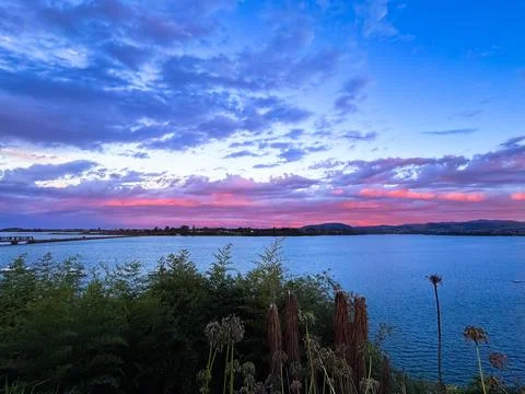 Vibrant sunset sky with dramatic orange and blue clouds New Zealand Fotos Stock