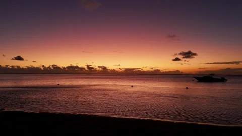 Vibrant sunset sky over a calm ocean, warm golden and purple hues in Mauritius Stock Footage 314508165