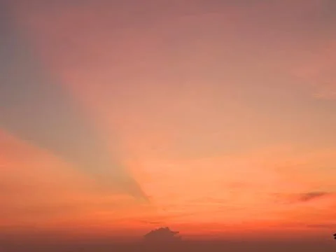 Vibrant sunset sky with soft orange crepuscular rays. Stock Photos