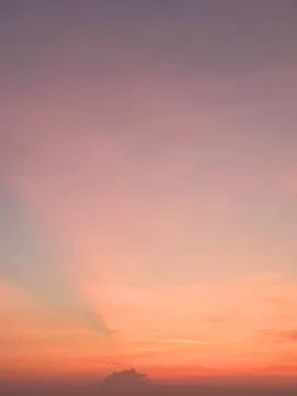 Vibrant sunset sky with soft orange crepuscular rays. Stock Photos