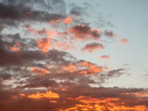 Vibrant sunset with textured clouds glowing in warm hues 写真素材