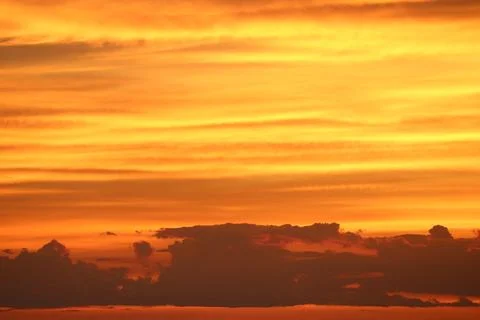 Vibrant Sunsets with Dramatic Clouds Creating a Golden Horizon Stock Photos