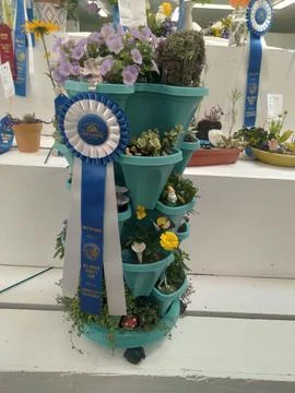 A vibrant tower of assorted flowers decorated with a ribbon Stock Photos