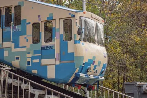 Vibrant train car with abstract patterns on tracks against a backdrop of lush Stock Photos